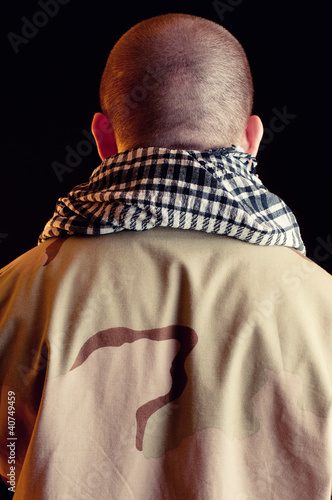 Foto: Mercenary in camo clothes standing with his back to the camera Mercenary in camo clothes standing with his back to the camera