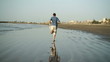 Young man jogging on the beach, slow motion