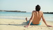 Young man sitting on the beach