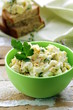 egg salad in a green cup with black bread