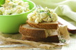 egg salad in a green cup with black bread