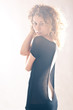Portrait of beautiful curly girl with black dress with back ligh