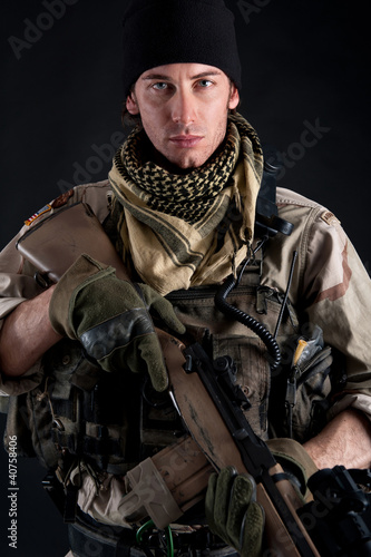 Photo: Soldier with rifle against black background. Soldier with rifle against black background.