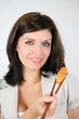 Woman eating a piece of sushi with chopsticks