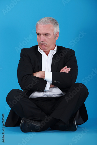 Photo: Grumpy man sitting on the floor Grumpy man sitting on the floor