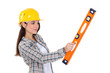 A female construction worker holding a level.