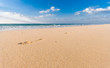Foto: sandy beach with lots of footprints and a blue sky with clouds sandy beach with lots of footprints and a blue sky with clouds