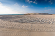 Foto: sandy beach with lots of footprints and a blue sky with clouds sandy beach with lots of footprints and a blue sky with clouds