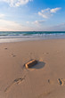 Foto: sandy beach with lots of footprints and a blue sky with clouds sandy beach with lots of footprints and a blue sky with clouds