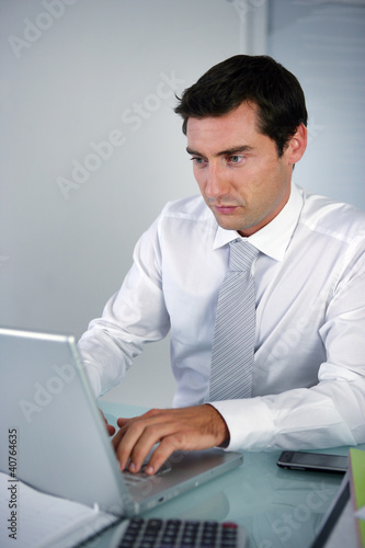 Photo: Banker sat a his desk Banker sat a his desk