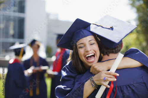 Photo: Smiling graduates hugging outdoors Smiling graduates hugging outdoors