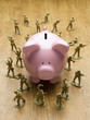 Toy army men surrounding piggy bank
