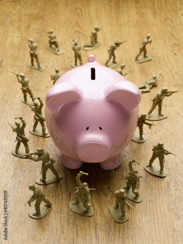 Photo: Toy army men surrounding piggy bank Toy army men surrounding piggy bank