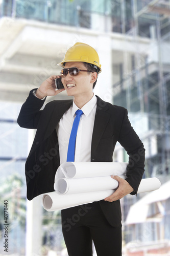 Photo: Asian engineer talking on the phone Asian engineer talking on the phone