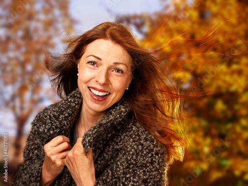 Foto: smiling woman in autumnal surrounding smiling woman in autumnal surrounding
