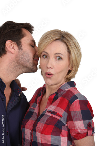 Photo: Man talking to woman's ear Man talking to woman's ear