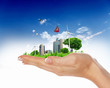 Human hand holding a green landscape