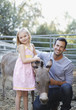 Father and daughter petting donkey