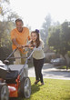 Father and daughter mowing lawn together