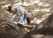 Father helping son climb tree outdoors
