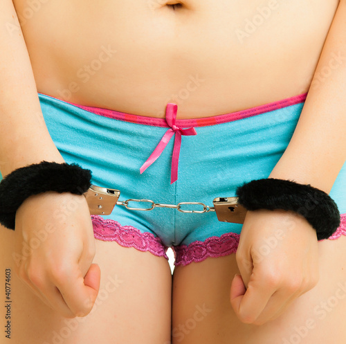 Photo: Girl in panties and handcuffs isolated on white Girl in panties and handcuffs isolated on white