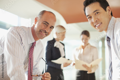 Photo: Businessmen talking in office Businessmen talking in office