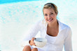 blonde sitting on the edge of swimming-pool