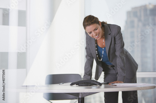 Photo: Businesswoman talking on speaker phone Businesswoman talking on speaker phone