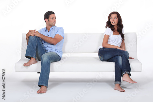 Photo: couple sitting apart in couch after quarrel couple sitting apart in couch after quarrel