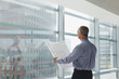 Businessman reading blueprint in office