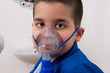 Little boy with asthma using nebuliser at clinic.