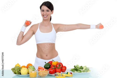 Photo: Woman in gym-wear stood with vegetables Woman in gym-wear stood with vegetables