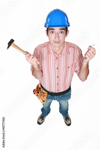 Photo: Tradesman holding a hammer and a nail Tradesman holding a hammer and a nail