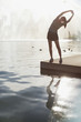 Woman stretching by still lake