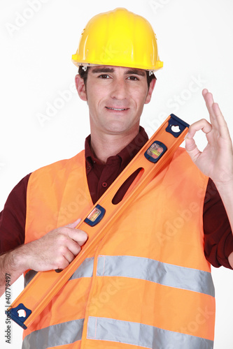 Photo: Man with spirit-level giving the ok sign Man with spirit-level giving the ok sign