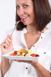 Woman eating fruit salad Woman eating fruit salad