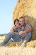 Farmer and wife sat on hay bale