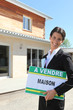 Estate agent standing in front of a house