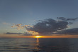 Sun setting over waves on beach
