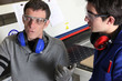 Factory worker explaining something to a colleague