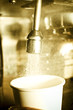 Water pouring from faucet into cup