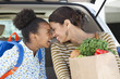 Mother and daughter unloading groceries from car