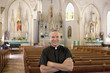 Priest smiling in ornate church