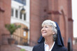 Smiling nun walking outdoors