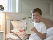 Boy reading Bible in bed