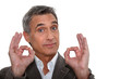 A mature businessman making an  ok sign.
