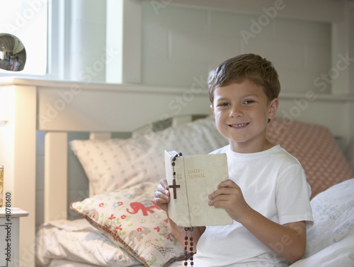 Photo: Boy reading Bible in bed Boy reading Bible in bed