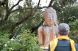 Older man examining Buddha statue