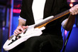 Young guitar player performing in night club