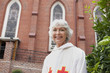 Smiling reverend standing outside church